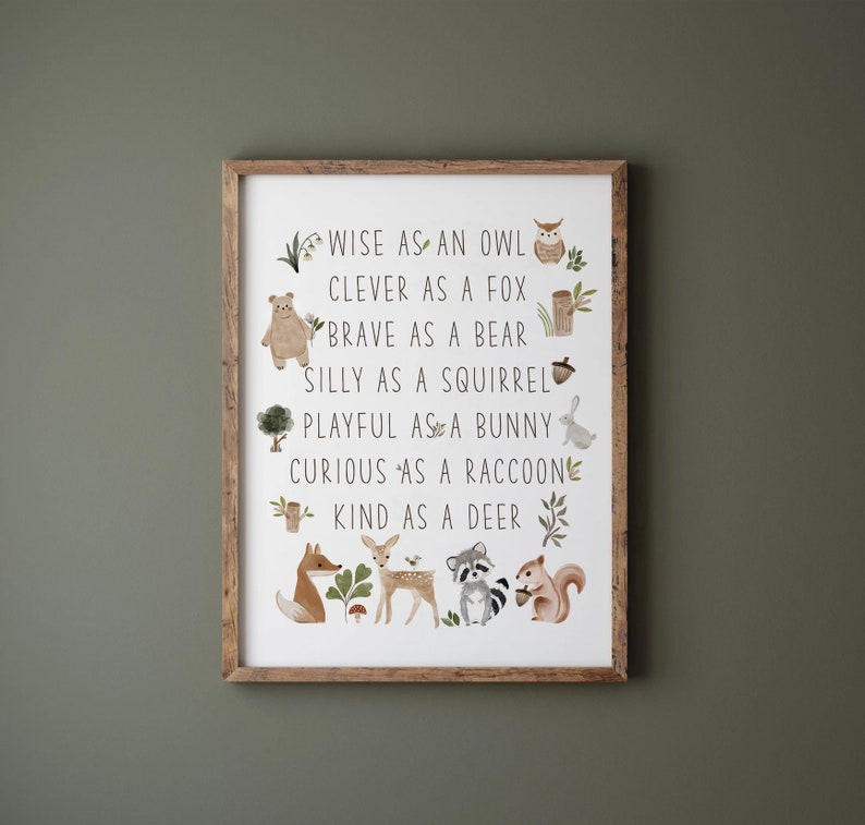 May include: A framed print with a white background and brown wood frame. The print features a list of animal adjectives with illustrations of the animals. The text reads: "Wise as an owl, Clever as a fox, Brave as a bear, Silly as a squirrel, Playful as a bunny, Curious as a raccoon, Kind as a deer."