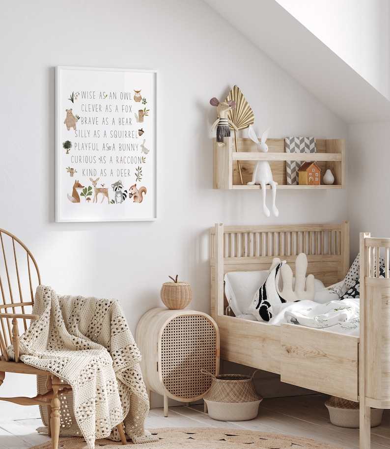 May include: A white framed print with a light brown background and illustrations of woodland animals. The text reads "WISE AS AN OWL, CLEVER AS A FOX, BRAVE AS A BEAR, SILLY AS A SQUIRREL, PLAYFUL AS A BUNNY, CURIOUS AS A RACCOON, KIND AS A DEER".