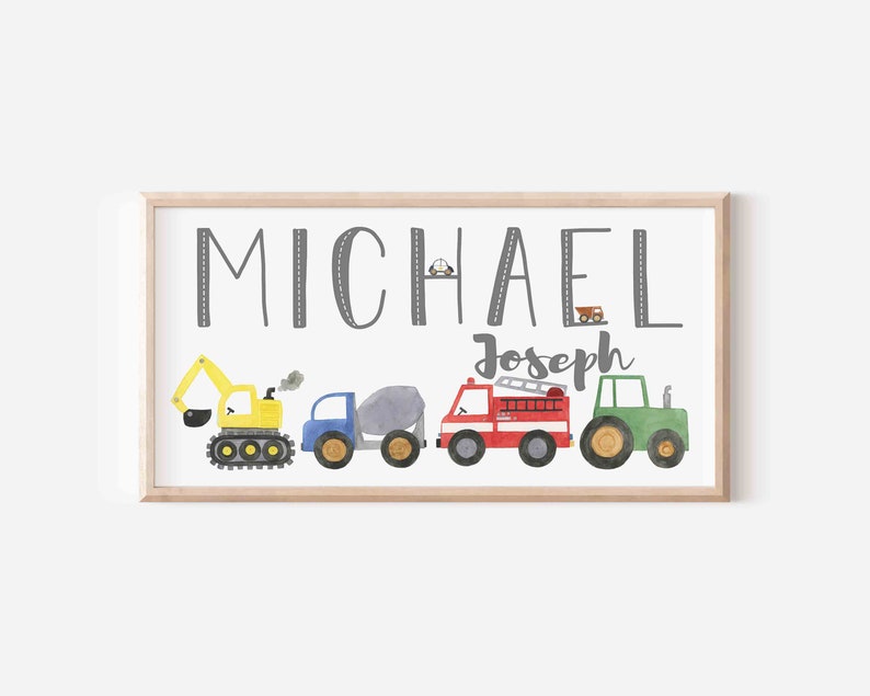 K&ouml;nnte beinhalten: Ein gerahmter Druck mit dem Namen "MICHAEL Joseph" in grauer Schrift. Der Druck zeigt eine Reihe von f&uuml;nf bunten Spielzeugfahrzeugen, darunter einen gelben Bagger, einen blauen Betonmischer, einen roten Feuerwehrwagen und einen gr&uuml;nen Traktor.