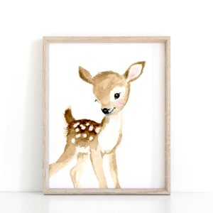 May include: A watercolor painting of a brown and white spotted fawn with pink cheeks, looking to the left. The fawn is standing on a white background.