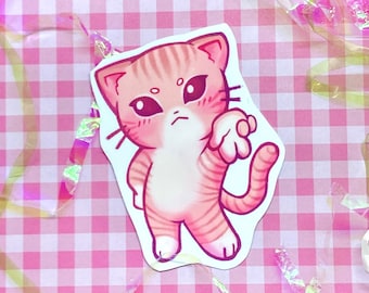 May include: A pink and orange cartoon cat sticker with a grumpy expression. The cat is standing on its hind legs with its front paw raised.