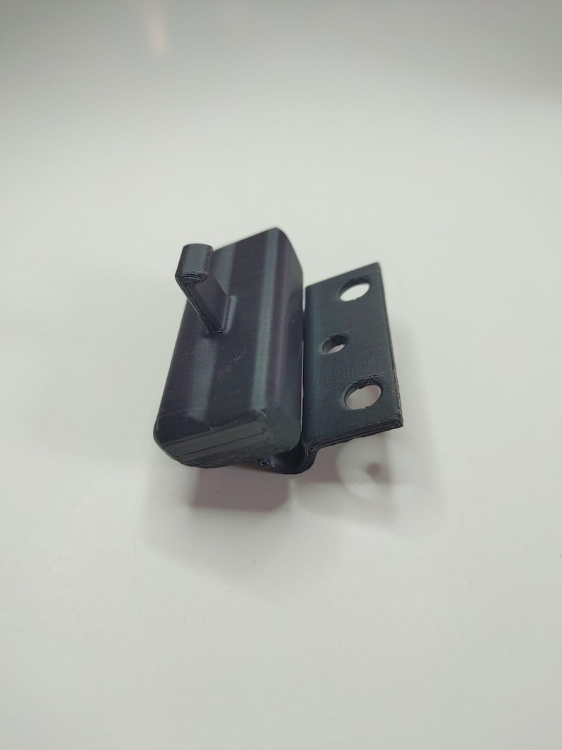 Puede incluir: Una bisagra de pl&aacute;stico negro con tres agujeros y un peque&ntilde;o gancho en el lateral.