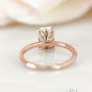 May include: A rose gold engagement ring with a square-shaped diamond set in a delicate floral design.