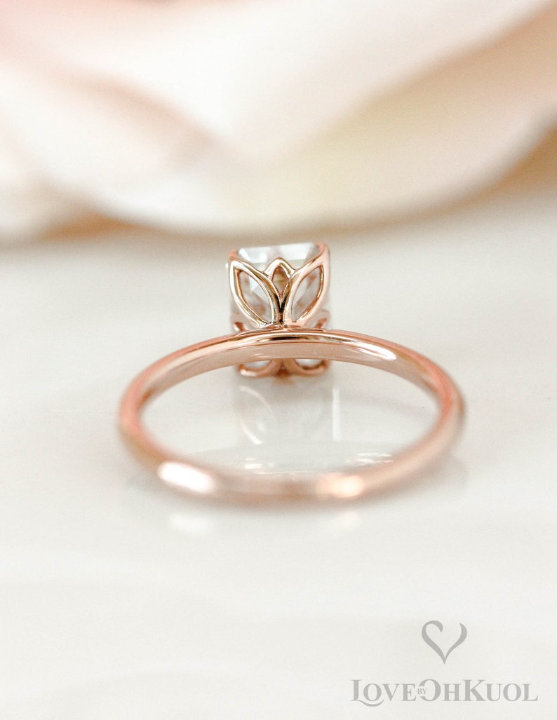 May include: A rose gold engagement ring with a square-shaped diamond set in a delicate floral design.