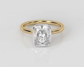 Könnte beinhalten: Ein goldener Verlobungsring mit einem Kissen-Schliff-Diamanten in einer Zargenfassung.