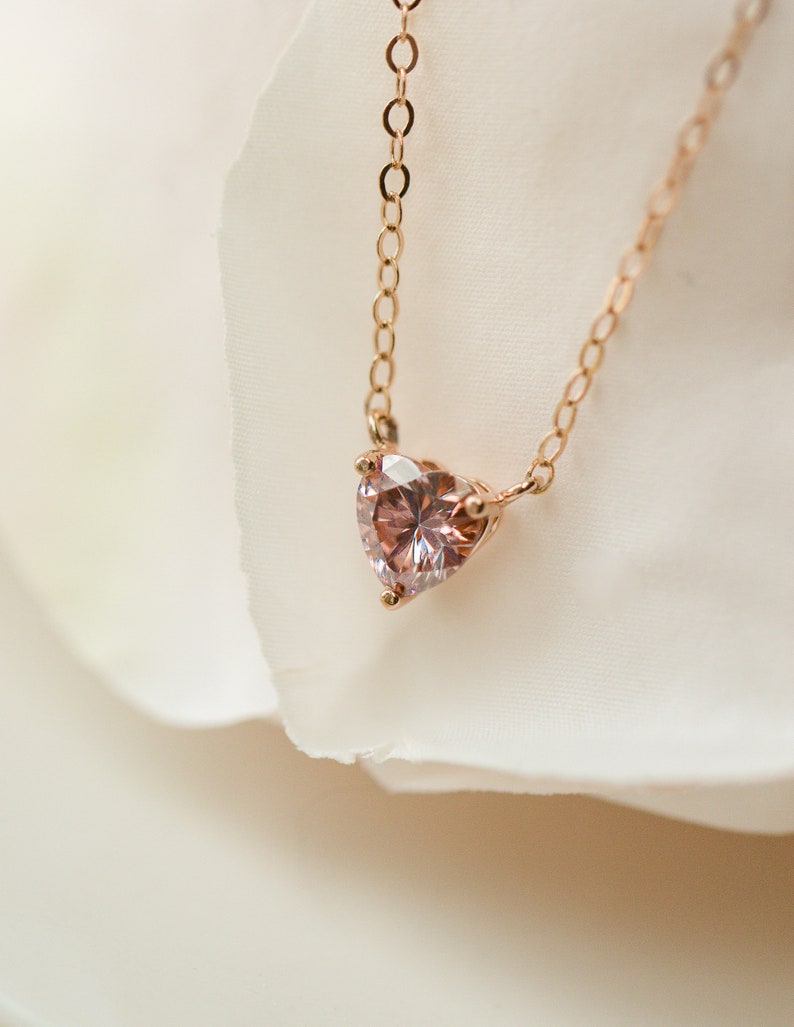 Puede incluir: Un delicado collar de oro rosa con un colgante de piedra preciosa rosa en forma de coraz&oacute;n.
