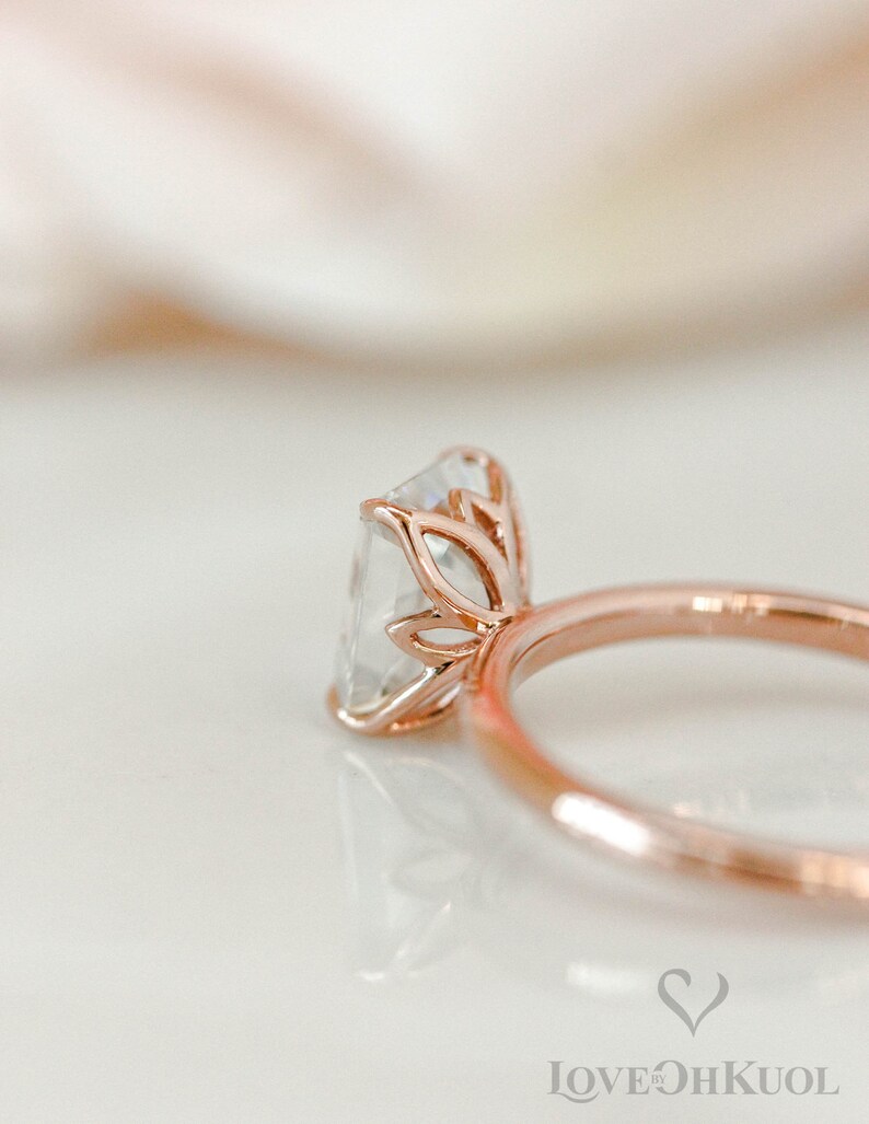 May include: A rose gold engagement ring with a square-shaped diamond set in a delicate floral design.