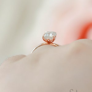 May include: A rose gold engagement ring with a square-shaped diamond.