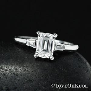 Anillo de compromiso de oro blanco con moissanita de talla esmeralda: tres piedras y diamante de laboratorio.