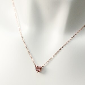 Puede incluir: Un delicado collar de oro rosa con un peque&ntilde;o colgante en forma de coraz&oacute;n rosa.