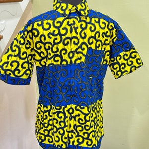May include: A short-sleeved button-up shirt with a yellow and blue patterned design. The pattern features black swirls on a yellow background and blue swirls on a blue background.