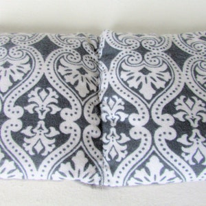 Puede incluir: Dos almohadas rectangulares con un patr&oacute;n de damasco gris y blanco. El patr&oacute;n presenta un dise&ntilde;o floral repetitivo. Las almohadas est&aacute;n hechas de una tela suave y se colocan una al lado de la otra sobre una superficie blanca.