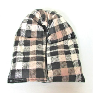 May include: A black, white, and pink plaid neck wrap filled with rice for heating or cooling. The wrap has a label that reads "Divine Comfort Rice Packs".