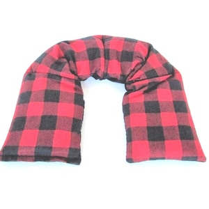 May include: Red and black buffalo plaid neck pillow. The pillow is shaped like a horseshoe and is filled with buckwheat hulls.