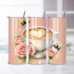 May include: Three pink insulated tumblers with a watercolor design. The design features a cup of coffee with a heart-shaped foam design, pink roses, and bumblebees. Each tumbler has a silver straw and a pink lid.