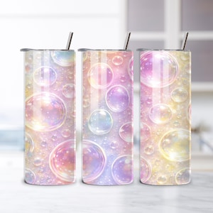 Può includere: Tre bicchieri in acciaio inossidabile con un design a bolle colorate. Il design presenta bolle grandi e piccole in tonalità di rosa, viola e giallo. Ogni bicchiere ha una cannuccia argentata e un coperchio grigio.