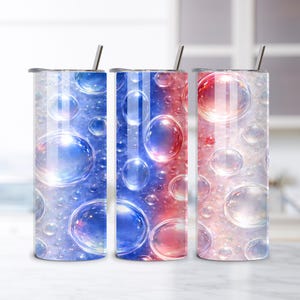 Può includere: Tre bicchieri isolati in acciaio inossidabile con disegni a bolle. I bicchieri presentano una sfumatura di colori, tra cui blu, rosso e bianco, con una cannuccia. Il design dà l'impressione di bolle che fluttuano nell'acqua.