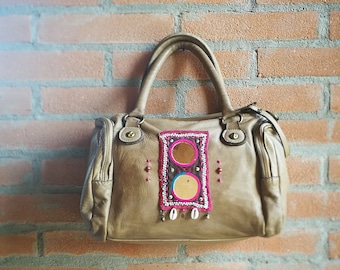 Distressed leather handbag with Banjara mirror embroidery and cowrie shells, taupe and pink