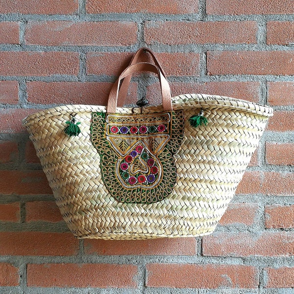 Bolso de paja con asas de cuero y decoración bohemia.