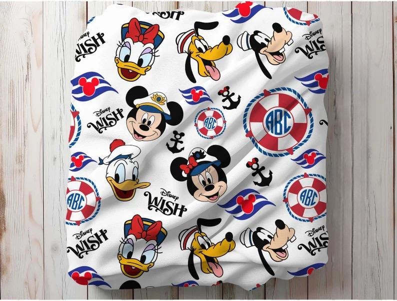 May include: White fabric featuring a repeating pattern of Disney characters including Mickey Mouse, Minnie Mouse, Donald Duck, Daisy Duck, and Goofy. The design also includes anchors, life preservers, and the text "Disney Wish".