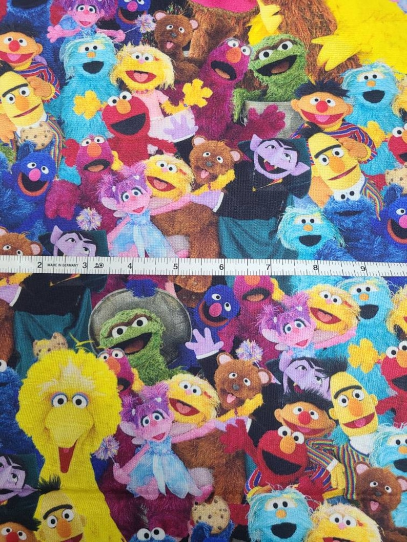 May include: A colourful fabric featuring a variety of Sesame Street characters, including Big Bird, Elmo, Cookie Monster, and Oscar the Grouch. The fabric is perfect for crafting projects, such as quilts, pillows, and tote bags.
