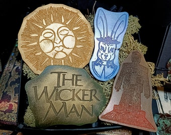 Peut inclure: Un ensemble de cinq plaques en bois décoratives représentant des images du film "The Wicker Man". Les plaques sont de formes et de tailles variées et présentent un soleil, un lapin, un homme et les mots "The Wicker Man".
