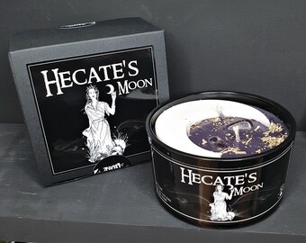 May include: A black candle jar with a white crescent moon design. The candle is purple with gold flakes and a clear crystal embedded in the wax. The jar has the text "Hecate's Moon" printed on the side.