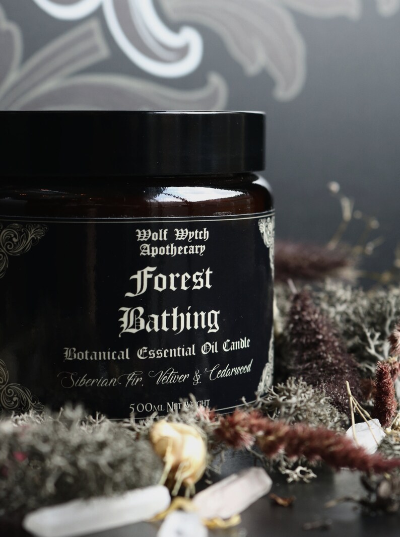 K&ouml;nnte beinhalten: Ein schwarzes Glasgef&auml;&szlig; mit einem schwarzen Etikett, auf dem "Wolf Wytch Apothecary Forest Bathing Botanical Essential Oil Candle Siberian Fir, Vetiver & Cedarwood 500ml NET WEIGHT" steht.