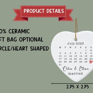 May include: White ceramic heart-shaped ornament with a calendar for July 2023. The calendar has the date 30 circled in pink. The text "Chloe & Ethan married" is written below the calendar.