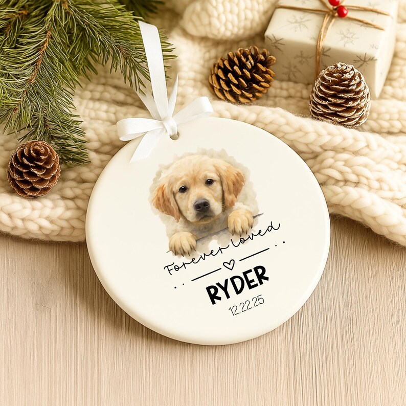 Puede incluir: Adorno redondo de cer&aacute;mica color crema con un retrato de cachorro golden retriever. El adorno tiene una cinta blanca para colgar y la inscripci&oacute;n "Forever Loved", el nombre "RYDER" y una fecha.