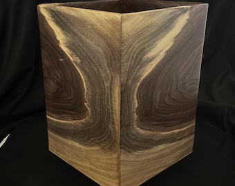 Cubo de basura de madera de nogal negro veteado, con cuatro esquinas a juego.
