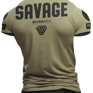 Puede incluir: Una camiseta verde caqui con la palabra "SAVAGE" impresa en negro en la espalda. La camiseta también presenta un logotipo negro con el texto "GYMISH LIFESTYLE" en la espalda.