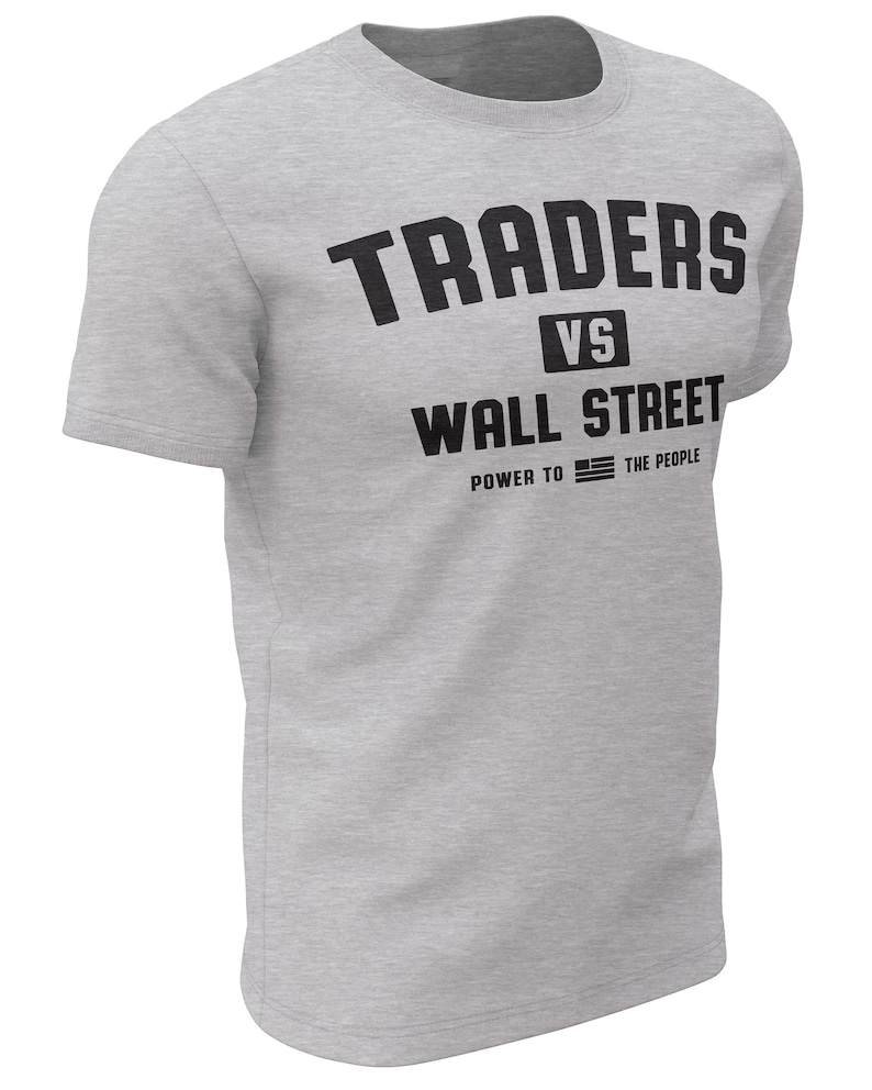 May include: Gray t-shirt with black text that reads "TRADERS VS WALL STREET POWER TO THE PEOPLE" with an American flag graphic.