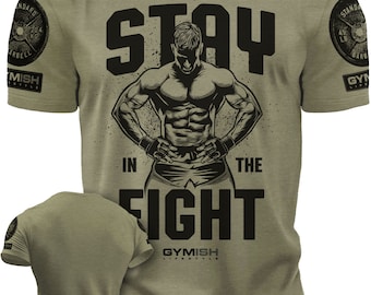 May include: A green t-shirt with a black graphic of a muscular man with the text "STAY IN THE FIGHT" and the logo "GYMISH LIFESTYLE".