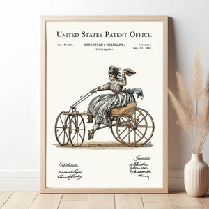 Puede incluir: Ilustración enmarcada de una patente de velocípedo, que muestra a una mujer montando el vehículo. La obra de arte está en tonos sepia con algunos acentos de color. El texto dice "United States Patent Office" e incluye detalles de la patente.