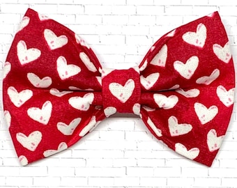 May include: Red bow tie with a white heart pattern.