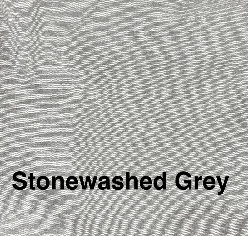 May include: Close-up of a textured, stonewashed grey fabric. The words "Stonewashed Grey" are printed in black, centered at the bottom of the image. The fabric has a subtle, mottled appearance.