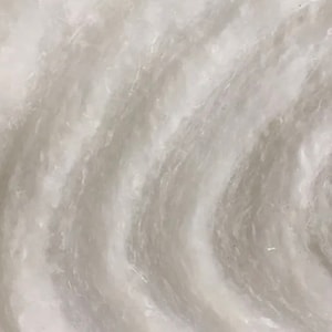 May include: Close-up of a white, textured surface with a swirling pattern. The surface has a smooth, almost silky feel.