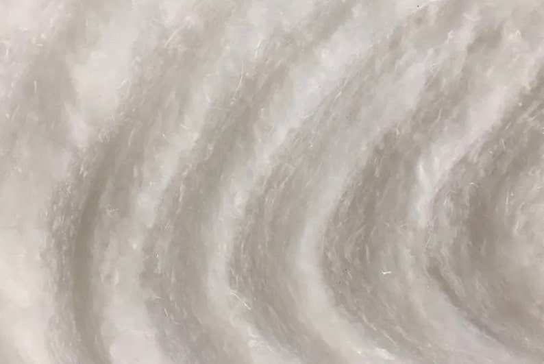 May include: Close-up of a white, textured surface with a swirling pattern. The surface has a smooth, almost silky feel.