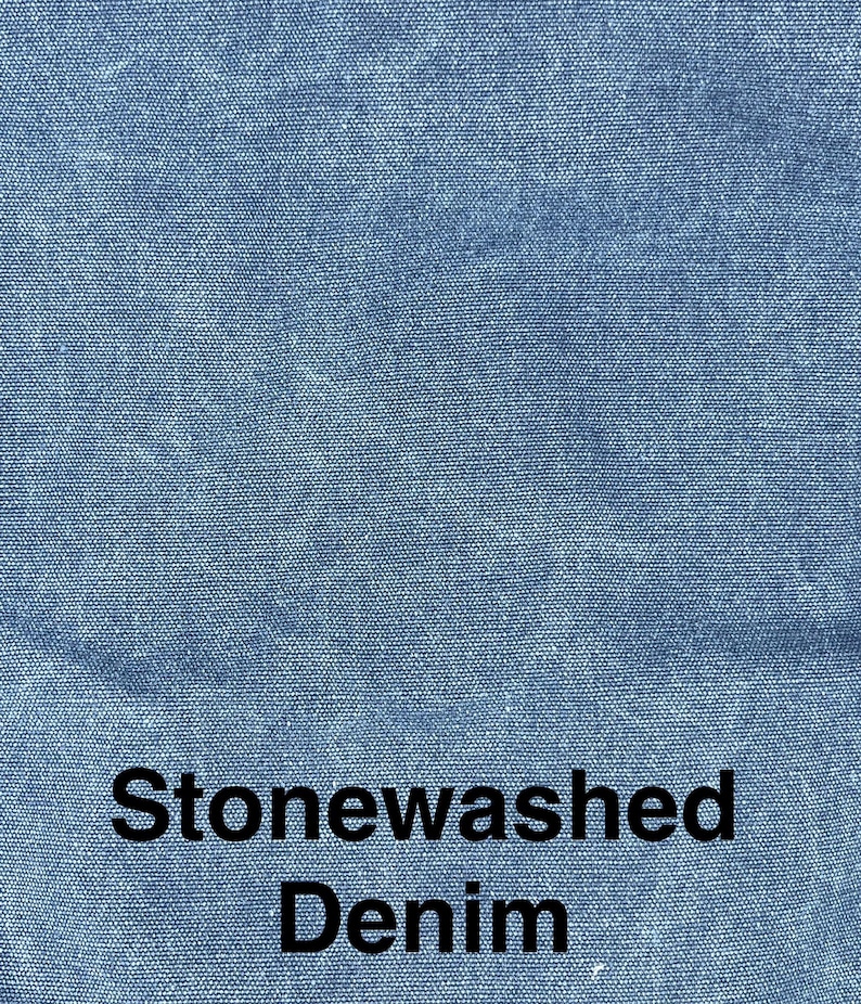 May include: Close-up of stonewashed denim fabric in a light blue color. The fabric has a textured appearance with a subtle, faded effect. The words "Stonewashed Denim" are printed in black, centered at the bottom of the image.
