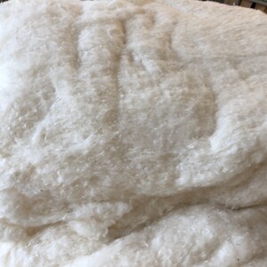 May include: A large pile of white cotton batting, a fluffy and soft material used for stuffing pillows, quilts, and other crafts.