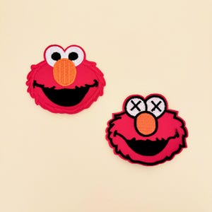 May include: Two embroidered patches featuring the red, furry character Elmo. The left patch shows the character with standard white eyes and black pupils. The right patch shows the character with white eyes featuring black X symbols instead of pupils.