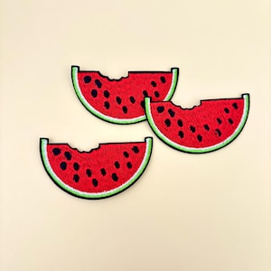 May include: Three red watermelon slices with green rinds and black seeds. Each slice has a bite taken out of it.