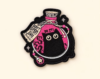 May include: An embroidered patch featuring a pink potion bottle with a black cat inside. The bottle has a cork stopper and a beige tag that reads DON'T OPEN EVIL inside. Above the cat, the text DO IT! is embroidered in black thread.