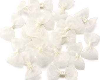 May include: A collection of white sheer ribbon bows. The bows are tied with a small white knot in the center.