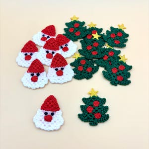 May include: Crocheted Christmas ornaments featuring Santa Claus faces with red hats and green Christmas trees with yellow star toppers. The Santa faces have white beards and red noses. The trees have red berry accents.