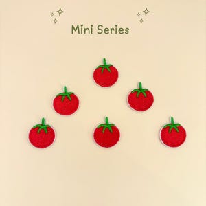 Pode incluir: Patches bordados com tomates vermelhos e caules verdes, sobre um fundo bege claro. O texto "Mini Series" est&aacute; no topo. Cada tomate tem uma borda branca.
