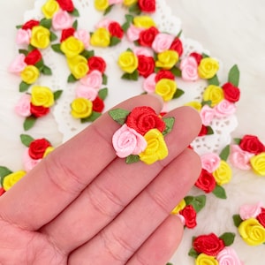 May include: Small, colorful fabric rose embellishments in red, pink, and yellow with green leaves. These miniature roses are ideal for crafting, scrapbooking, or adding a decorative touch to various projects. The roses are clustered together in small groups.