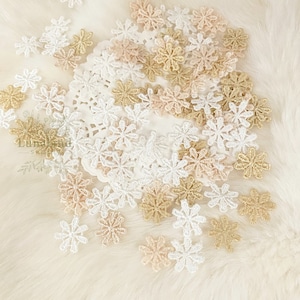 May include: Assortment of delicate lace flower embellishments in white, cream, and gold. These small, intricate flowers are perfect for adding a touch of elegance to crafts, clothing, and home decor.