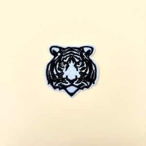 May include: Black embroidered iron-on patch of a tiger's face.